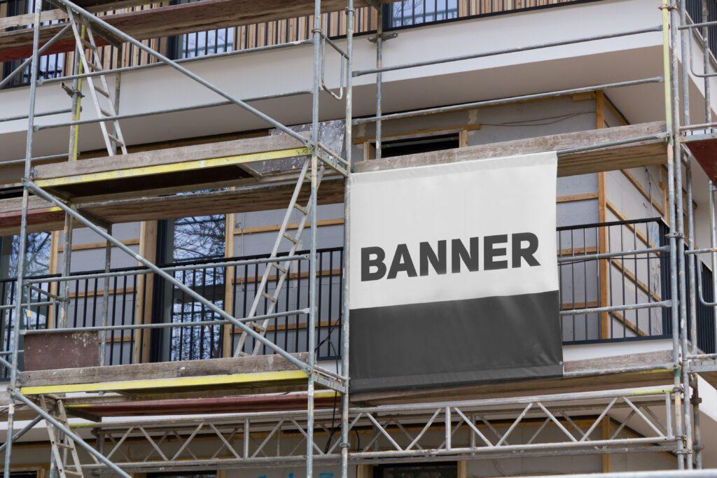 Gerüst mit Werbebanner auf Baustelle vor Wohngebäude